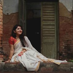 a woman sitting on the ledge of an old building