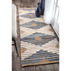 a blue and white rug on the floor next to a window with an open door