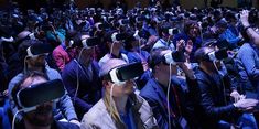 many people are wearing virtual headsets while sitting in the audience with their hands up