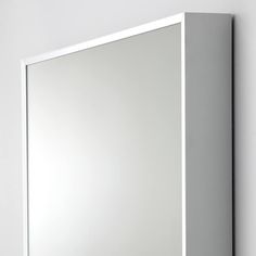 a bathroom mirror mounted to the side of a wall