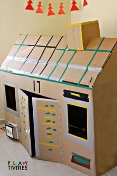 a cardboard house made to look like it is in the shape of a building with windows and doors