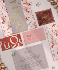 an assortment of greeting cards and envelopes with gold foil lettering on white paper surrounded by pearls