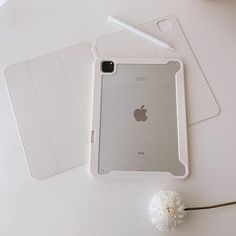 an ipad case sitting on top of a white table next to a flower and pen