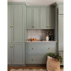 a kitchen filled with lots of green cupboards next to a white counter top oven