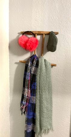 a coat rack with hats and scarves hanging on it