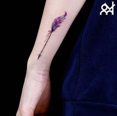 a woman's arm with a purple feather tattoo on it