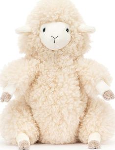 a white stuffed sheep sitting up against a white background