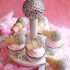 cupcakes and ice cream cones are arranged in a cone with pink icing