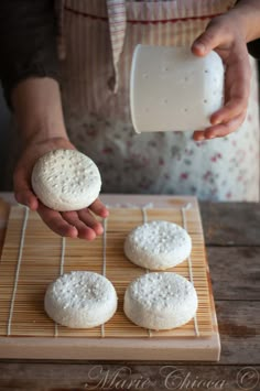 someone is pouring milk on some white cookies