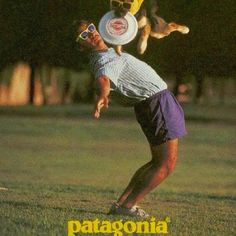 a man is catching a frisbee in the air with his dog on his back