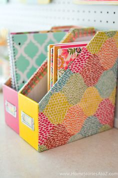 colorful binders are sitting in a box on the counter