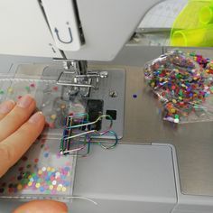 a person is working on something in a sewing machine with sprinkles all over it