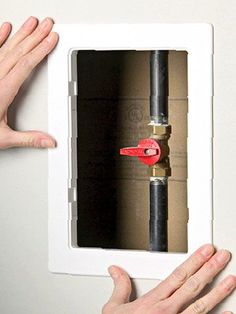 two hands are holding the door handle to an electrical outlet with a red tool in it