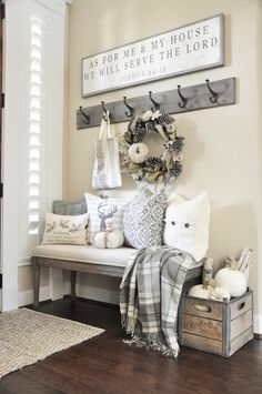 the entryway is decorated with white and gray accents, such as wreaths and pillows