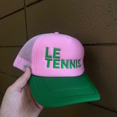 Le Tennis. Pink And Green- The Perfect Combo! Serve In Style With This New Hat. The Nylon And Mesh Trucker Hat Is The Perfect Unisex Accessory Snap-Back Closure One Size Fits Most Pink Flat Brim Baseball Cap For Summer, Pink Summer Baseball Cap With Flat Brim, Pink Curved Brim Baseball Cap For Spring, Fun Pink Hat One Size Fits Most, Casual Pink Mini Hat With Flat Brim, Adjustable Pink Baseball Cap For Summer, Pink Adjustable Trucker Hat For Summer, Pink Cap Mini Hat For Summer, Pink Short Brim Hat For Fun