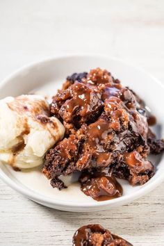 a white plate topped with meat covered in sauce and ice cream next to two bananas