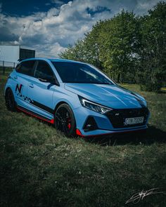 a blue car parked on top of a lush green field