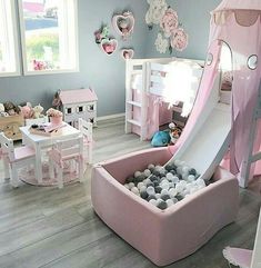 a child's bedroom with a pink slide in the center and lots of toys on the floor