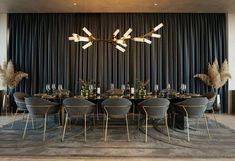 an elegant dining room with black chairs and gold accents