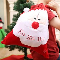 a little boy holding onto a santa clause pillow