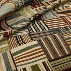 a multicolored patchwork fabric with stripes and squares on it's surface