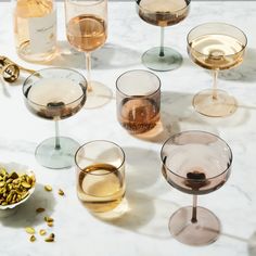 there are many glasses with different types of wine in them on the marble counter top