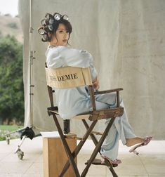 a woman sitting on top of a wooden chair