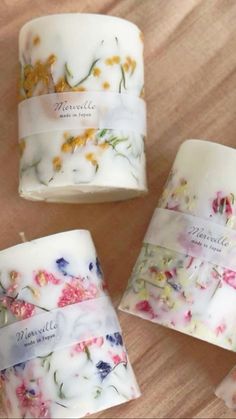 four different types of flowered candles on a table