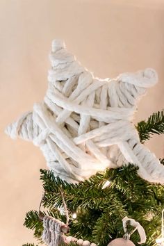 an ornament made out of yarn on top of a christmas tree