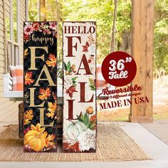 two tall wooden fall signs sitting on top of a door mat in front of a house