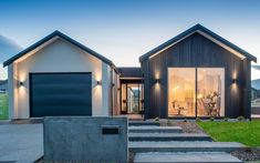 two modern houses with garages and stairs leading up to the front door at dusk