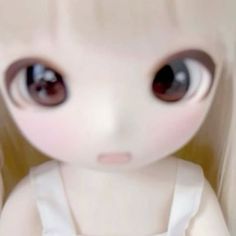 a close up of a doll with big eyes