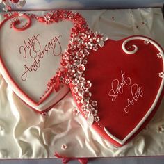 two heart shaped cakes with happy anniversary messages on them