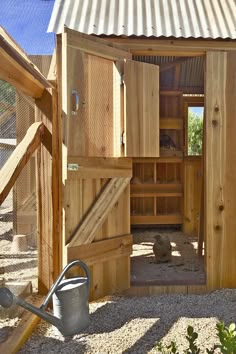 an outdoor chicken coop with wooden doors and windows