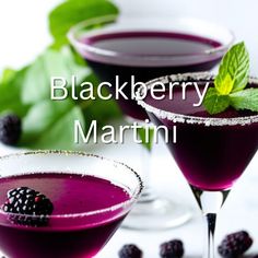 two glasses filled with blackberry martinis on top of a table