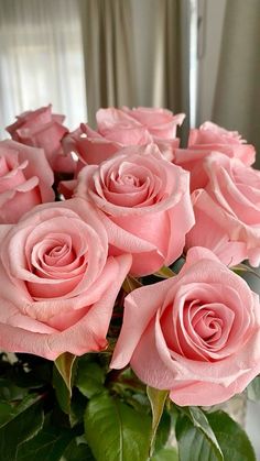 a vase filled with pink roses on top of a table