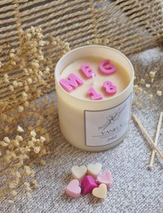 a candle with the word love spelled out on it next to some marshmallows