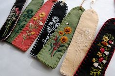 five handmade bookmarks with embroidered flowers on them