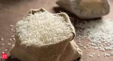 white rice in a burlock bag next to a sack of rice on a table