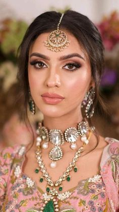 a woman wearing an elaborate necklace and earrings