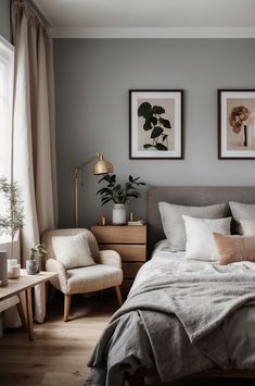 a bedroom with grey walls and white bedding, two framed pictures on the wall