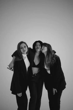 three women standing next to each other in black and white