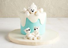 there is a small cake with two bears on the top and one bear in the middle