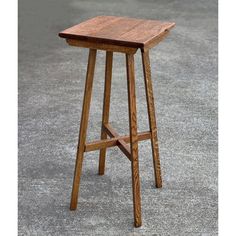 a wooden stool sitting on top of a cement floor