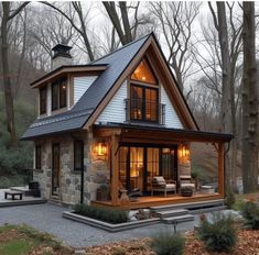 a small house in the woods with lots of windows and lights on it's roof