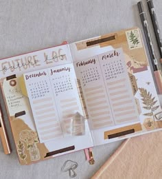 an open planner with some pens on top of it