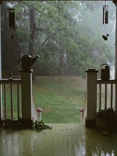 an open porch door with pots and pans hanging from it's sides in the rain