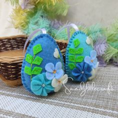 two blue slippers with green leaves and flowers on them sitting next to a basket