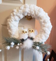 a white wreath with two owls on it