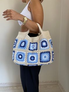 a woman carrying a crocheted bag in blue and white